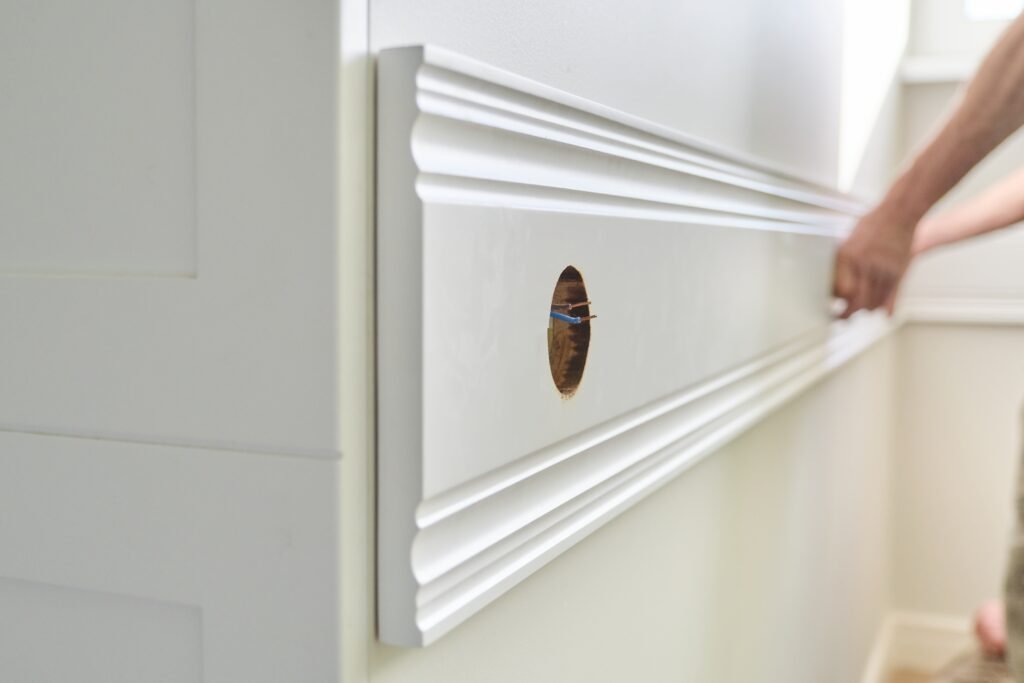 Bathroom Wall Molding Ideas: A Complete Makeover Guide closeup of gluing wooden white painted plank panel 2023 11 27 05 28 06 utc
