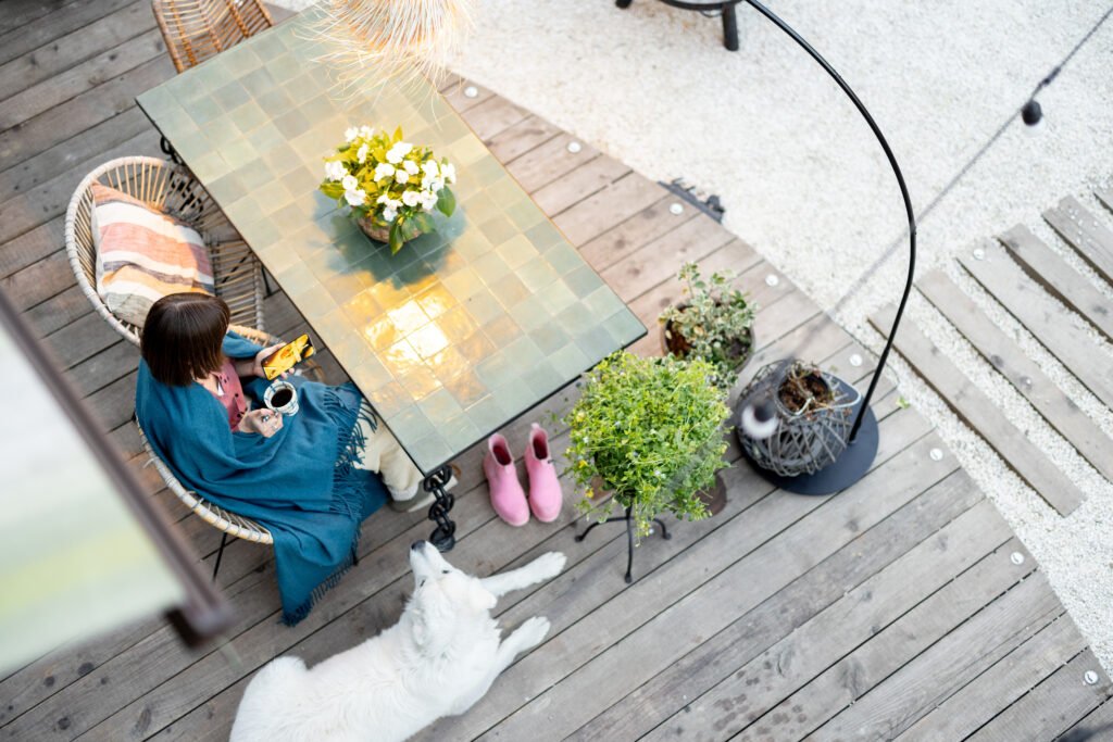 Transform Your Covered Patio - A Guide to Floor Ideas woman in plaid relaxing on home terrace 2023 11 27 05 00 30 utc